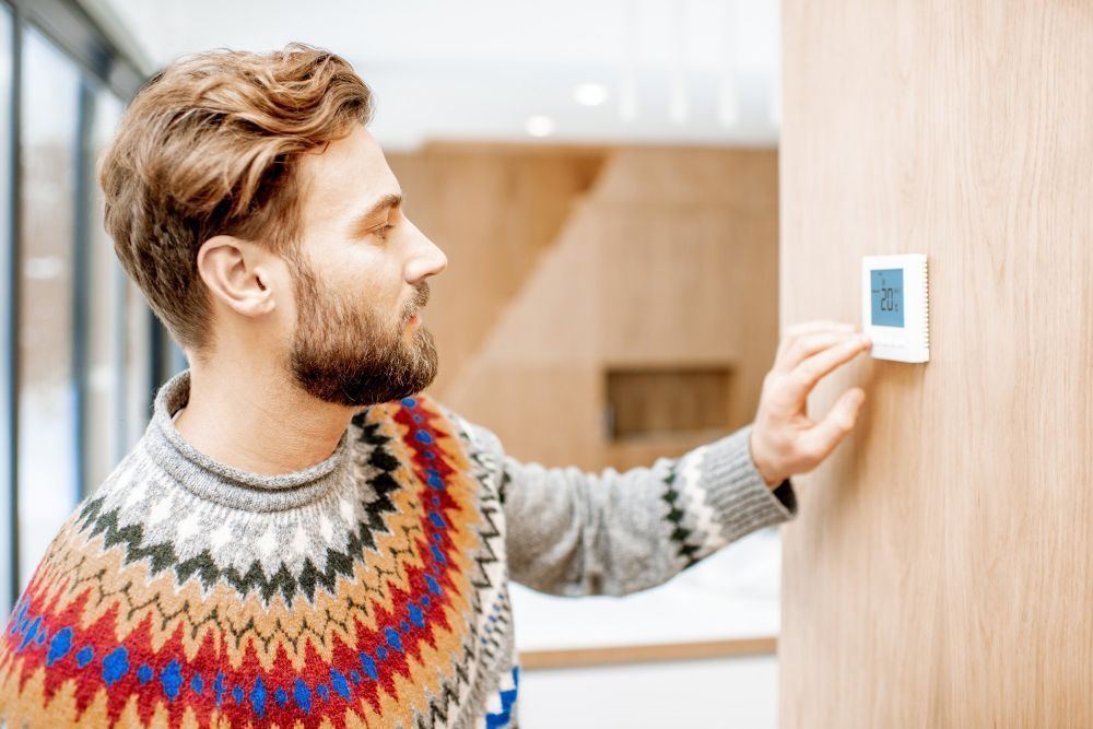 Homme qui allume son thermostat