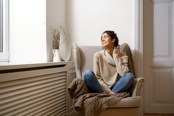 Une dame devant son radiateur 