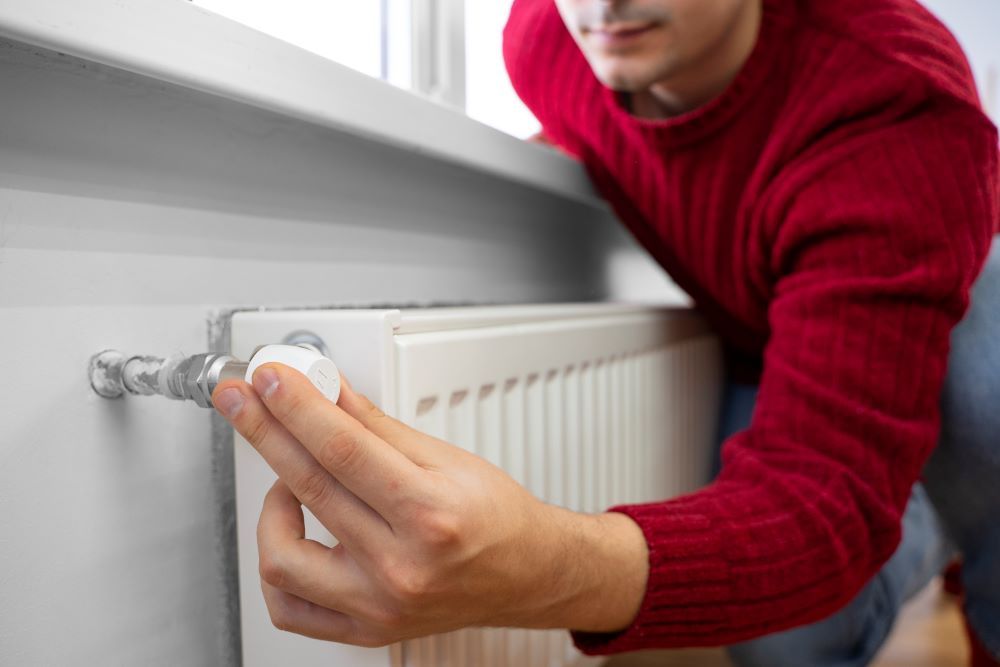 Un utilisateur teste le robinet  thermostatique d'un raditateur pour savoir s'il est temps de le changer.