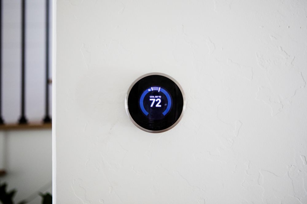 Thermostat intelligent fixé sur un mure blanc